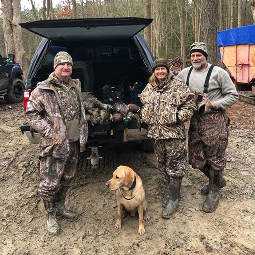 group of hunters with dog and dead ducks